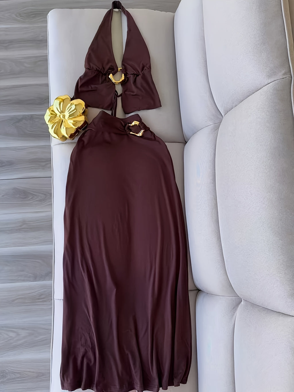 A Stylish And Sophisticated Set Featuring a Backless Halter Neck Top with a Unique Metallic Buckle, Paired with a Long Bodycon Skirt That Has an Elastic Waist