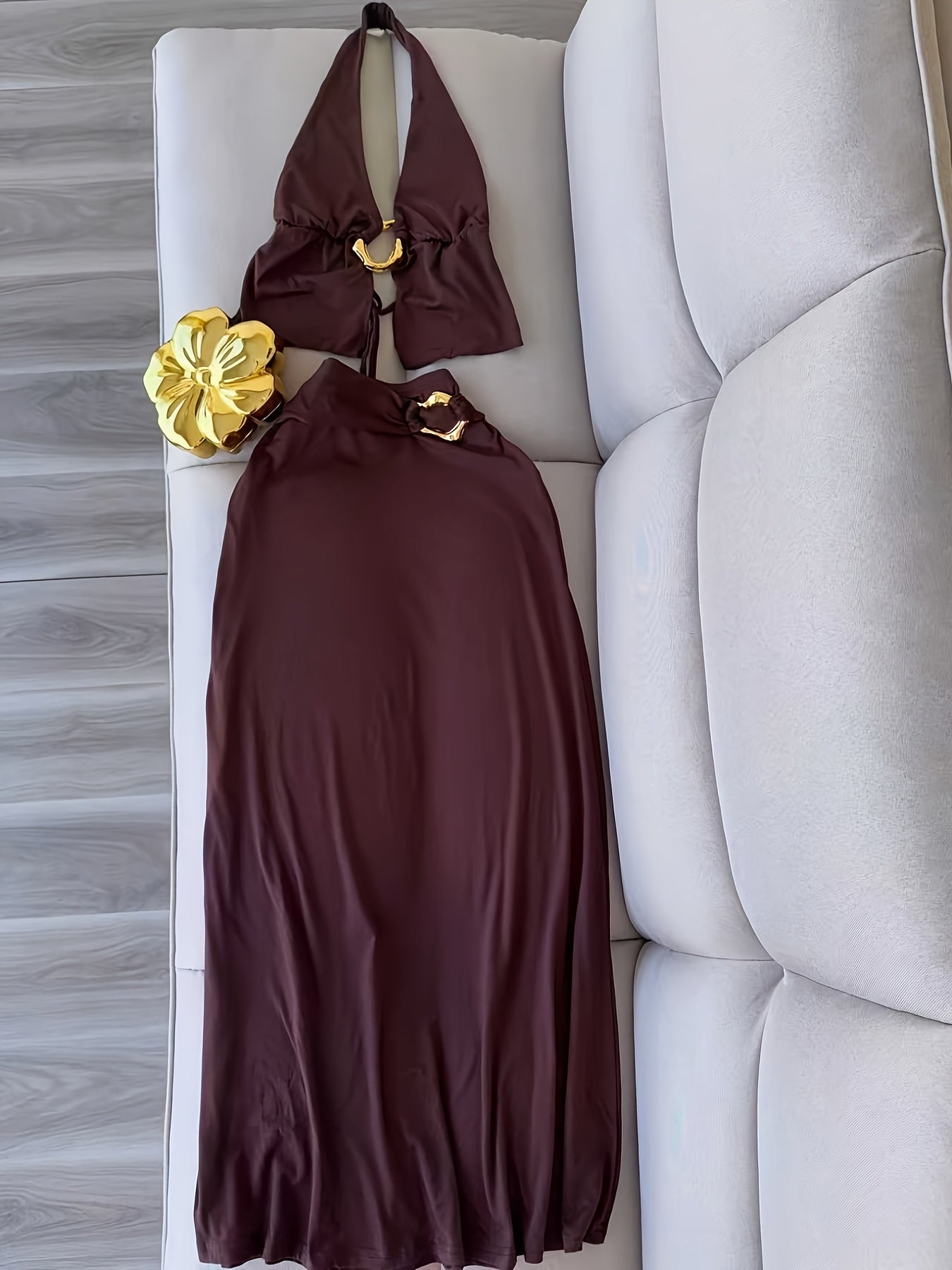 A Stylish And Sophisticated Set Featuring a Backless Halter Neck Top with a Unique Metallic Buckle, Paired with a Long Bodycon Skirt That Has an Elastic Waist