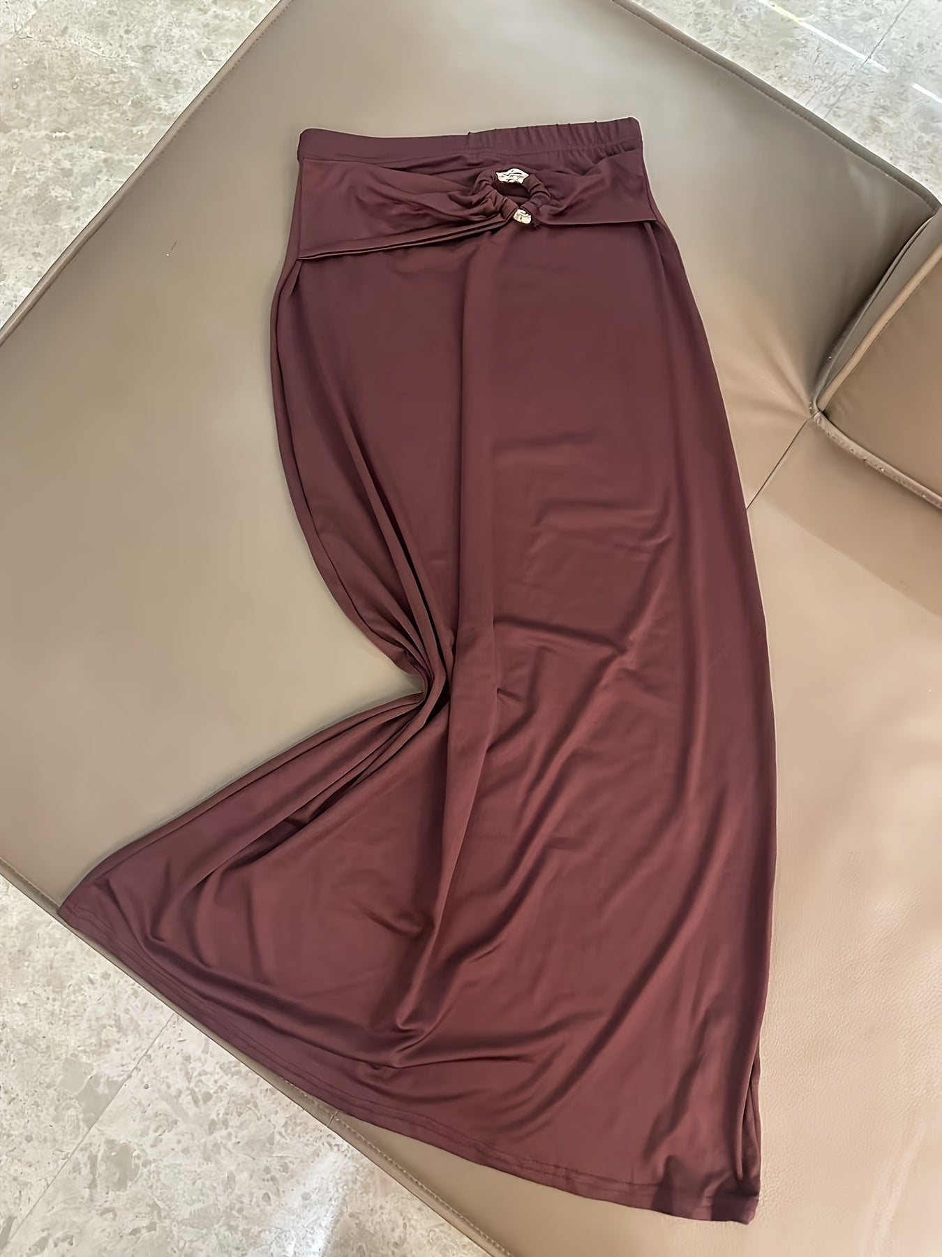 A Stylish And Sophisticated Set Featuring a Backless Halter Neck Top with a Unique Metallic Buckle, Paired with a Long Bodycon Skirt That Has an Elastic Waist
